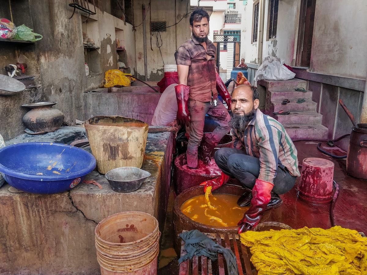 Workers soak clothes in a bucket for dyeing, at Sujangarh in Churu, Wednesday, April 24, 2019. Members of Chhipa Muslim community from Sujangarh in Churu, Rajasthan have been involved in tie & dye art of textile for centuries. (PTI Photo)