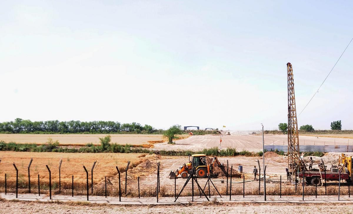 Heavy machines at work beyond the border fence for the construction of the Indian side of Kartarpur corridor, in Gurdaspur district. (PTI Photo)