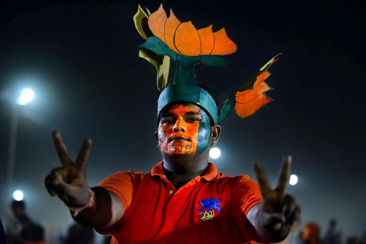A BJP supporter flashes victory sign during a election campaign rally by Prime Minister Narendra Modi for the ongoing Lok Sabha polls, in Prayagraj, on Thursday, May 9, 2019. (PTI Photo)