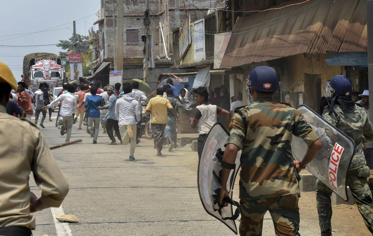 Police disperse a mob during a clash at a polling station at the sixth phase of Lok Sabha polls, in East Midnapore, Sunday, May 12, 2019. (PTI Photo)
