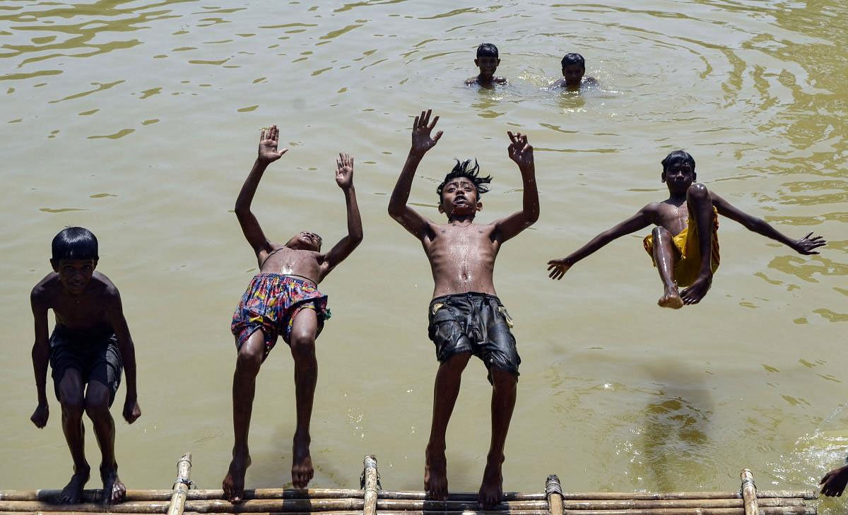 Children dive into a pond on a hot, summer day, in Dharmanagar, Tuesday, May 14, 2019. (PTI Photo)