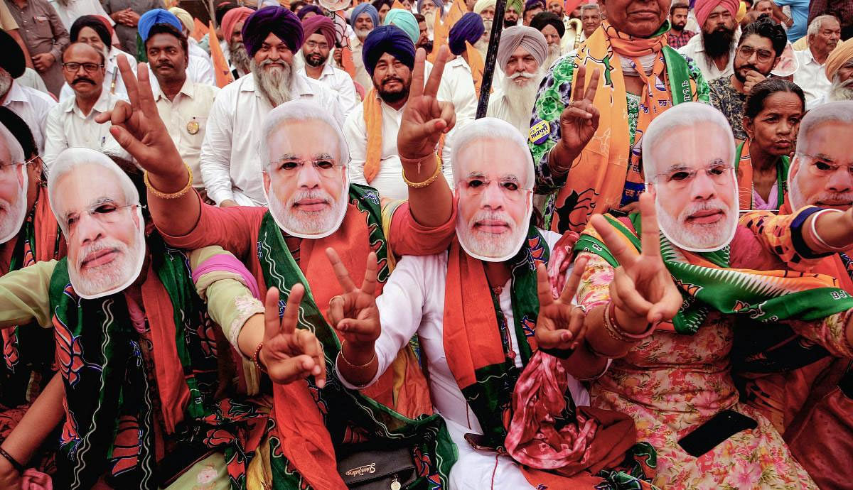 BJP supporters wear masks of Prime Minister Narendra Modi during an election rally for the last phase of the Lok Sabha polls, in Patiala, Thursday, May 16, 2019. (PTI Photo)
