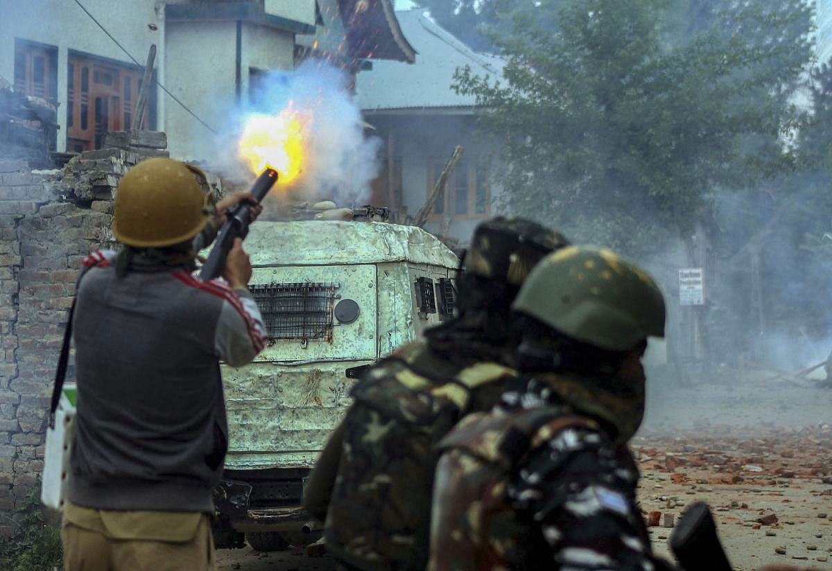 Policemen fire tear gas at protestors near the encounter site in which three top Jaish-e-Muhammad militant commanders, one army soldier and a civilian were killed, in Pulwama district, Thursday, May 16, 2019. (PTI Photo)