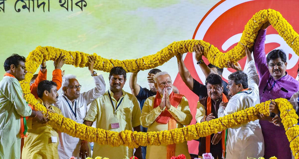 Prime Minister Narendra Modi being garlanded during an election campaign rally for the ongoing Lok Sabha polls, in Kolkata , Thursday, May 16, 2019. (PTI Photo)