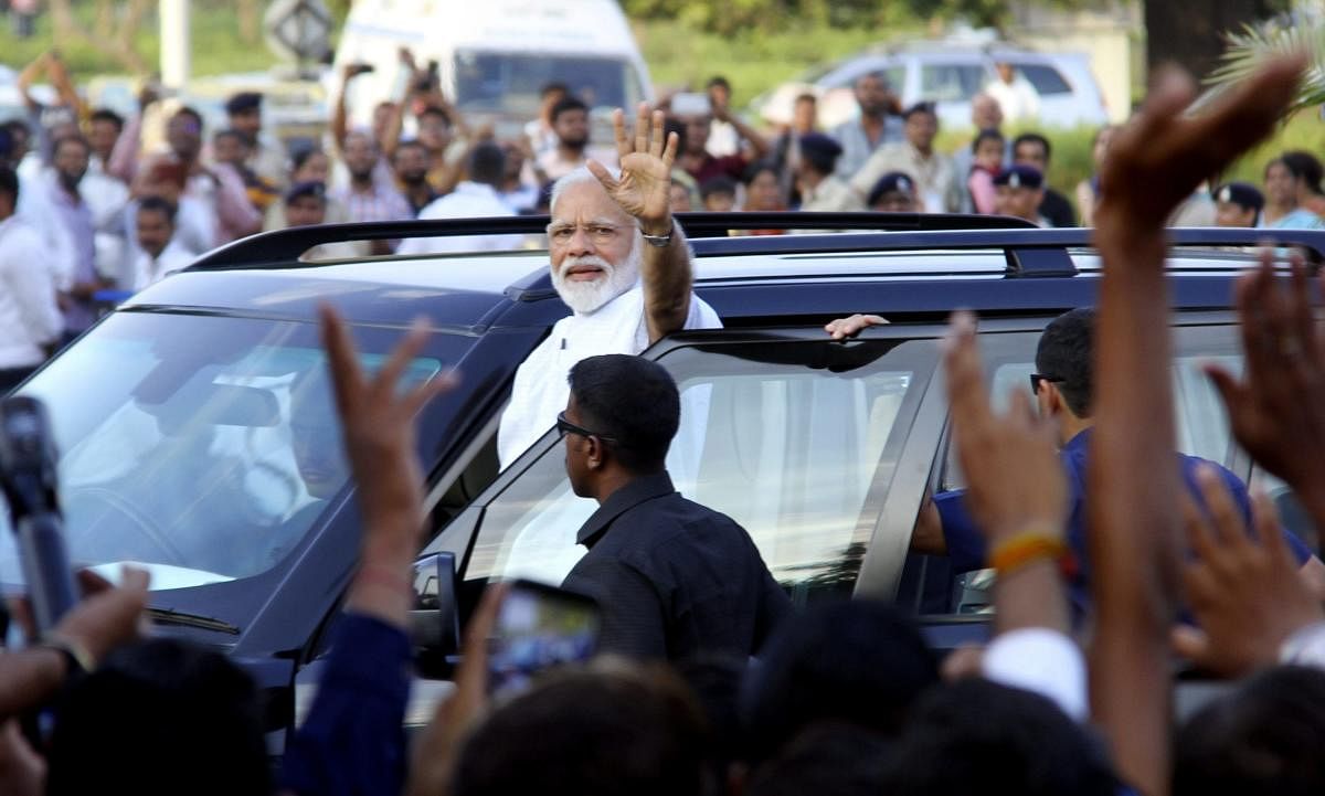 Prime Minister Narendra Modi waves at the supporters on his arrival at the airport in Ahmedabad. PTI Photo