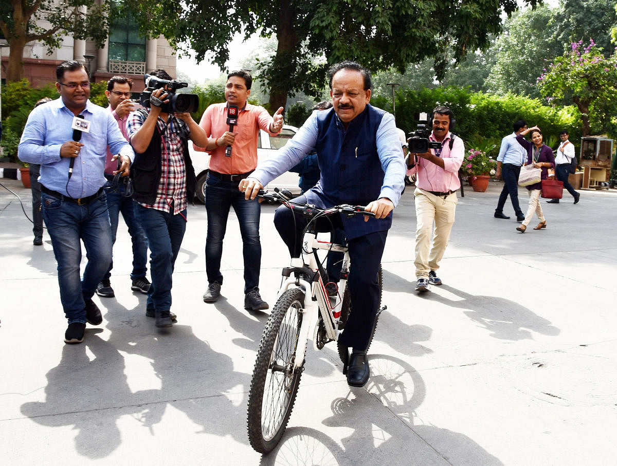 Harsh Vardhan arrives on a bicycle at Nirman Bhawan to take charge as Union Health Minister in the newly-elected PM Modi's cabinet, in New Delhi. (PTI Photo)