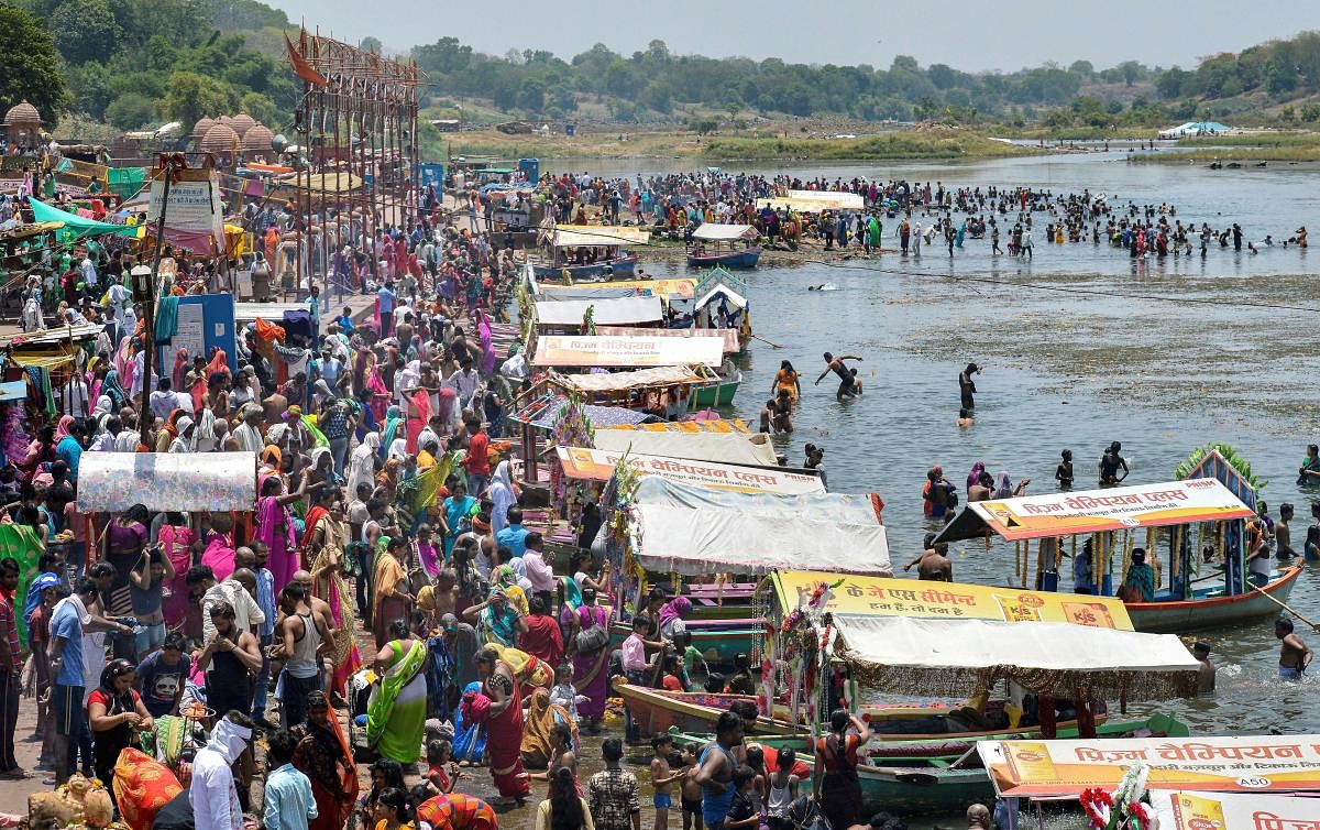 People gather at Gwarighat on the banks of river Narmada to take bath, on the occasion of Somvati Amavasya in Jabalpur. (PTI Photo)