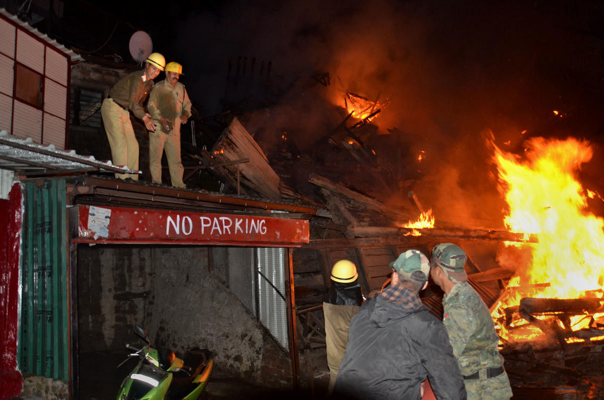 Firefighters douse a blaze which broke out in an old building, in Lakkar Market, Shimla, Thursday, June 6, 2019. (PTI Photo)