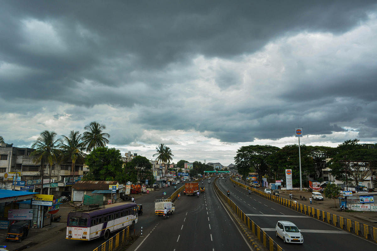 Vehicles ply on road as dark clouds hover in the sky, on Pune-Bangalore Nationl Highway, in Karad, Tuesday, June 11, 2019. (PTI Photo)