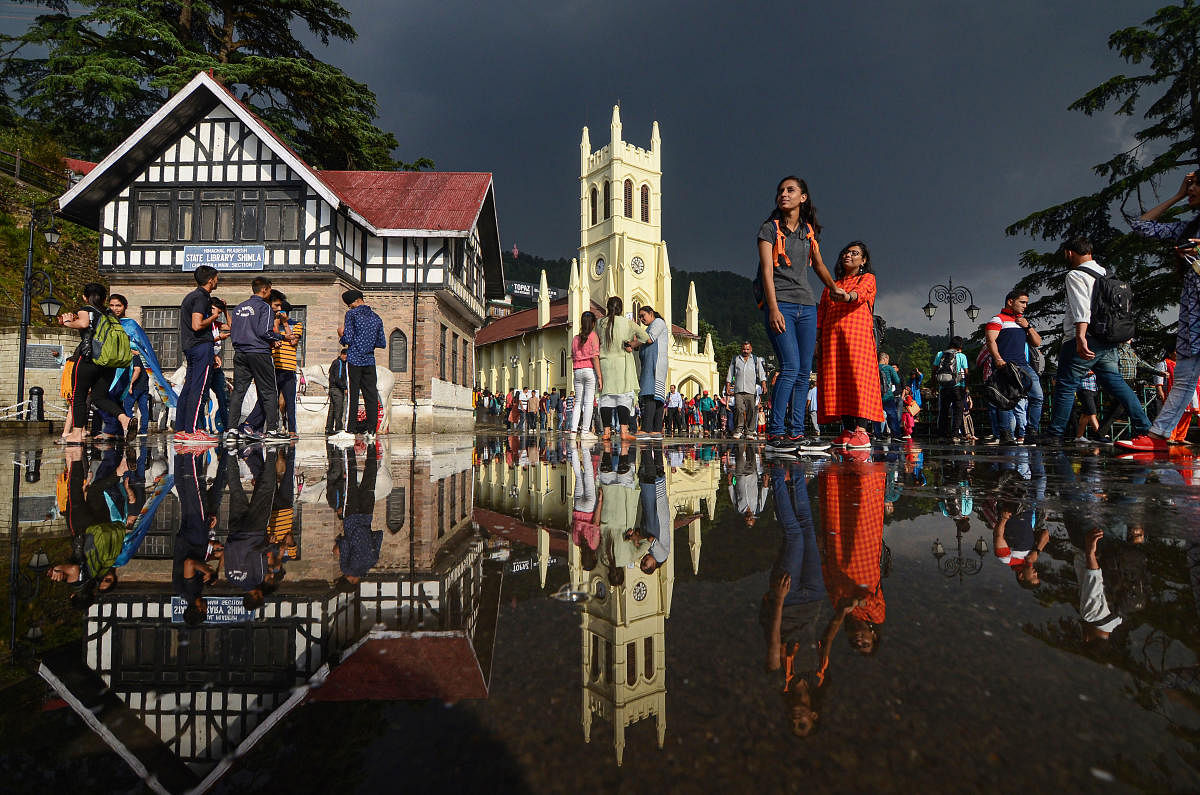 Tourists move out to the open after a rain shower as weather turned pleasant in the hill-station of Shimla, Tuesday, June 11, 2019. (PTI Photo)