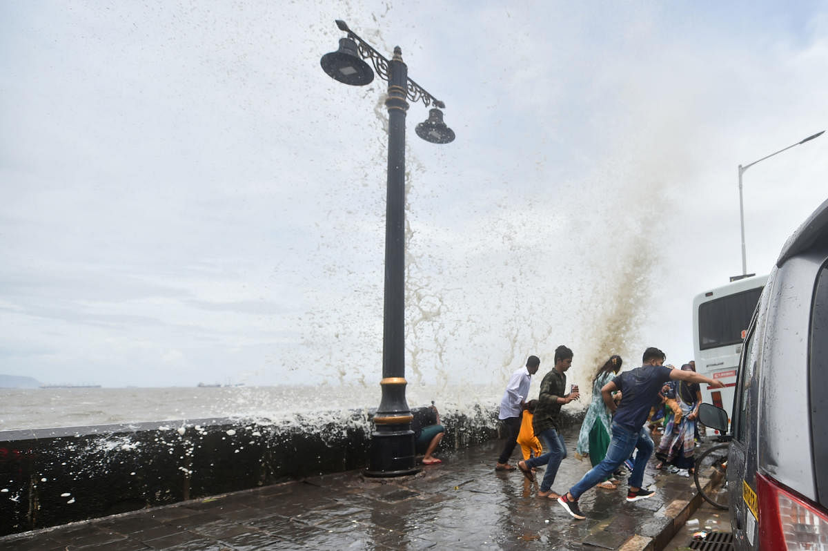 People react as a wave during high tide hits the seawall at Gateway of India, in Mumbai, Wednesday, June 12, 2019. (PTI Photo/Mitesh Bhuvad)