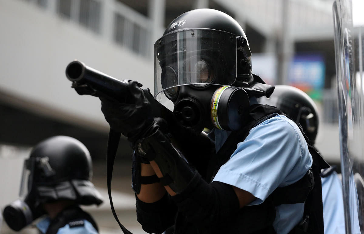 Police officer aims a tear gas gun at protesters during a demonstration against a proposed extradition bill in Hong Kong, China June 12, 2019. REUTERS/Athit Perawongmetha