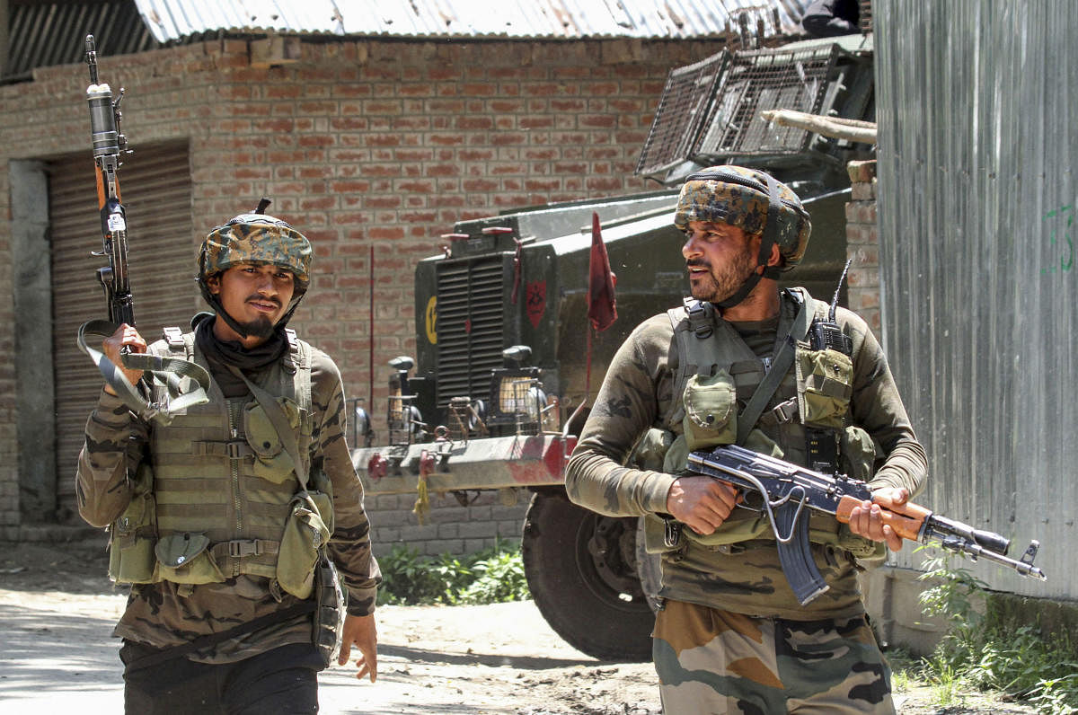 Army soldiers move towards the house, where two Lashkar-e-Taiba militants were hiding during an encounter, at Braw Bandina in Awantipora area of Pulwama, Friday, June 14, 2019. Two LeT militants were killed in an encounter with security forces in Pulwama district of Jammu and Kashmir on Friday, police said. PTI