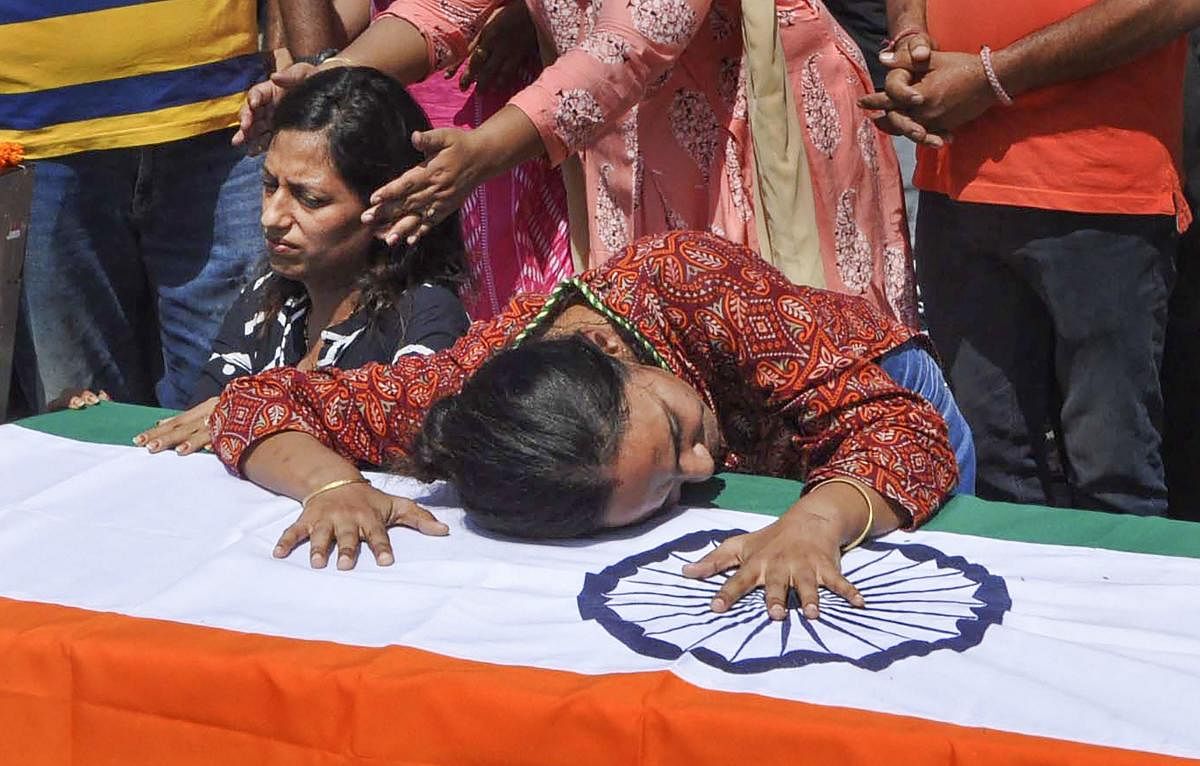 Wife and sister of Major Ketan Sharma mourn near his coffin, at RVC Centre, in Meerut, Tuesday, June 18, 2019. Sharma was killed in an encounter with militants in Jammu and Kashmir's Anantnag district on Monday. PTI