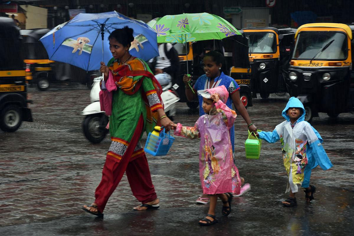 Pedestrians walk across a road during monsoon rain, in Thane, Monday, June 24, 2019. (PTI Photo)