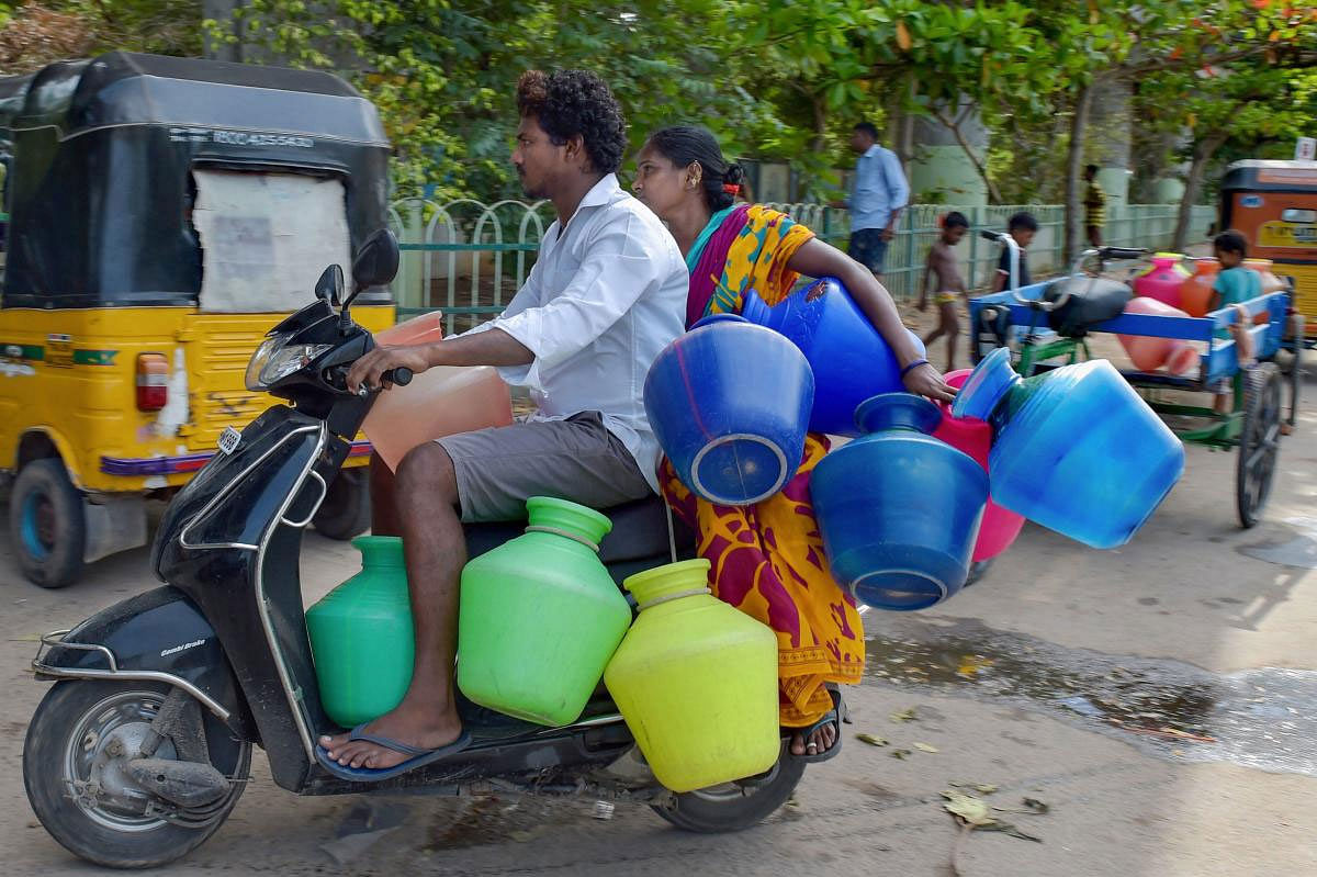 A couple rides on a scooter carrying empty vessels to fetch water from a municipal water tanker, following acute water shortage, in Chennai, Wednesday, June 26, 2019. (PTI Photo)