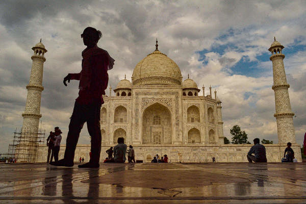 A silhouette of a person seen standing against the background of Taj Mahal on a cloudy day, in Agra.(PTI Photo)