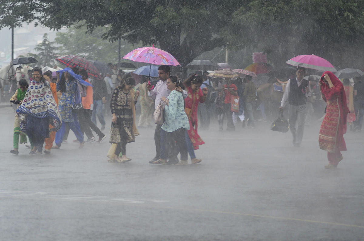Pedestrians use umbrellas to protect themselves from heavy rainfall, in Shimla, Friday, July 5, 2019. (PTI Photo)