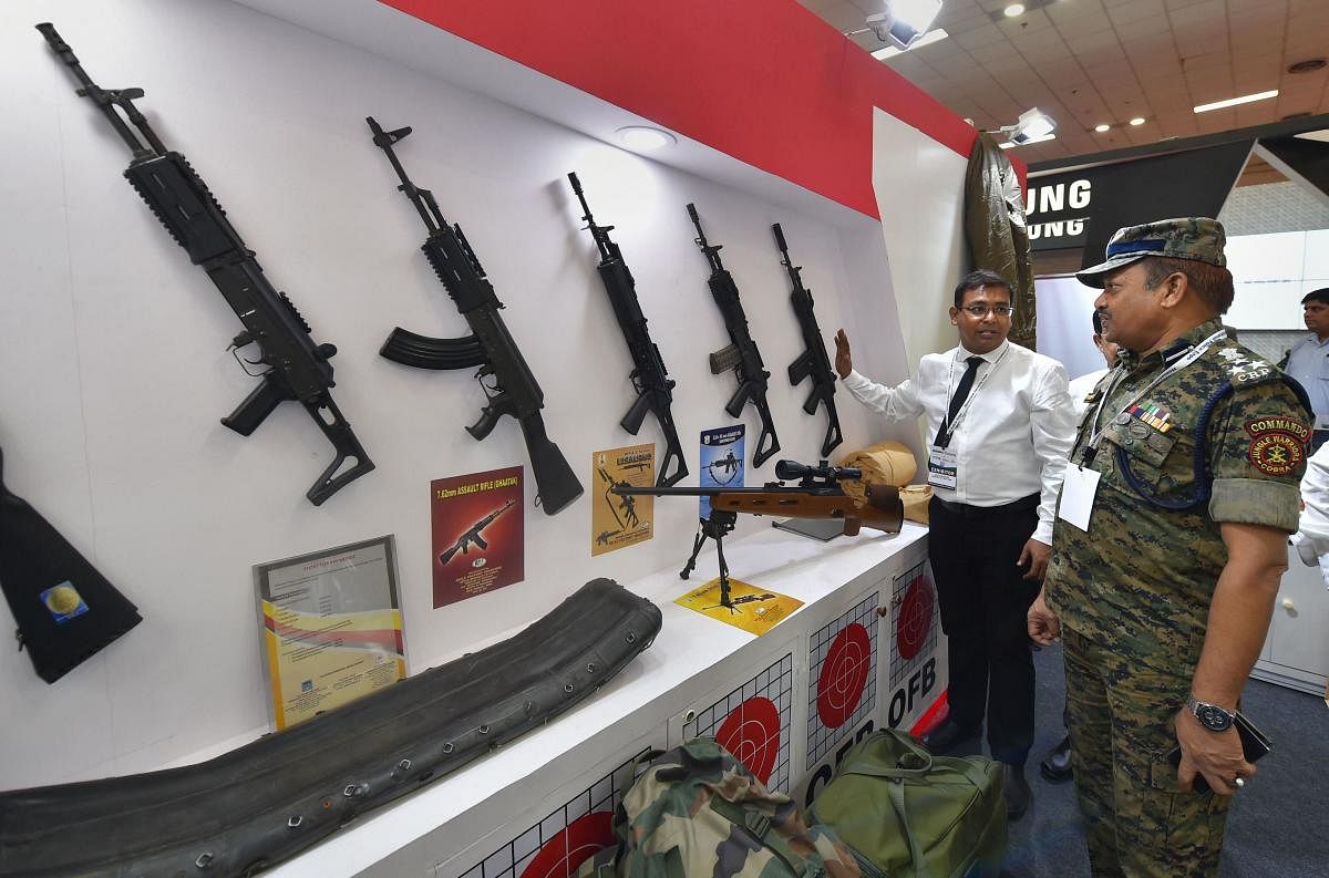 An exhibitor explains the features of a weapon to a visitor at the International Police Expo 2019, in New Delhi. (PTI Photo)