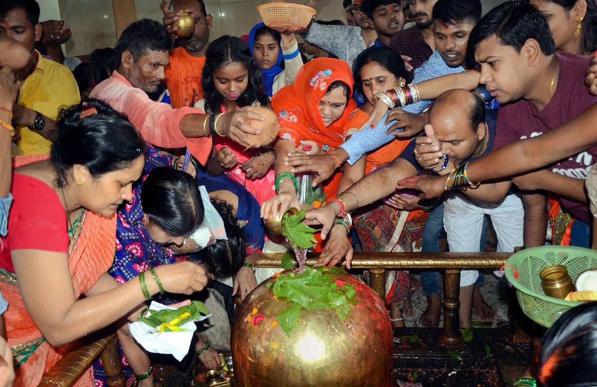Devotees perform 'Abhishek' of Lord Shiva on the first Somwar (Monday) of the holy month of Shravan, at Pahari temple in Ranchi. (PTI Photo)