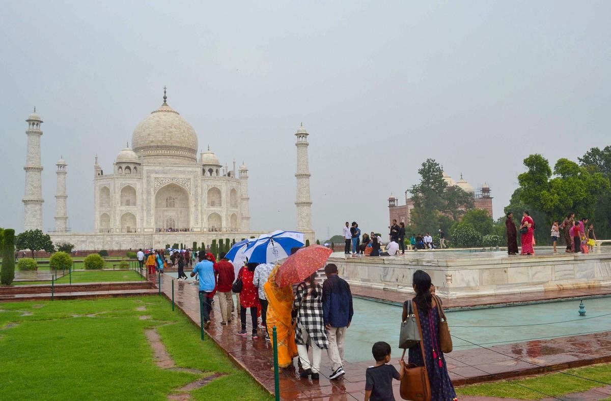 Tourists visit the Taj Mahal on a rainy day, in Agra. (PTI Photo)