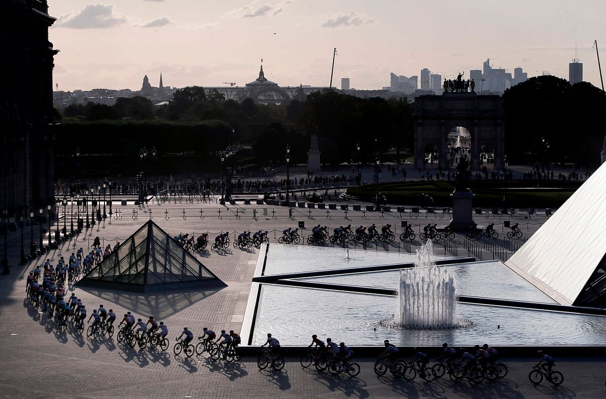 The pack rides through the courtyard of the Louvre museum by the Louvre pyramid designed by Ieoh Ming Pei during the 21st and last stage of the 106th edition of the Tour de France cycling race. (AFP)