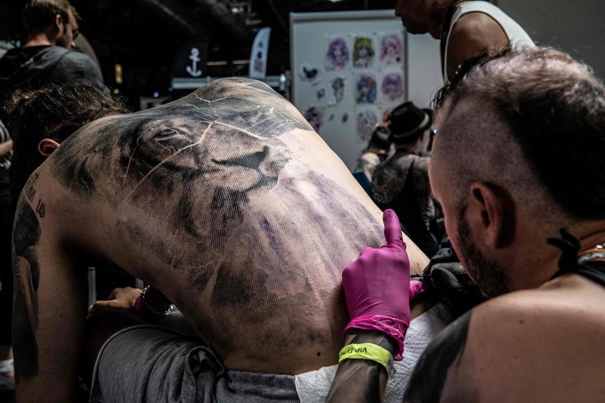 A man gets tattooed at the Tattoo Convention fair in Berlin. AFP Photo