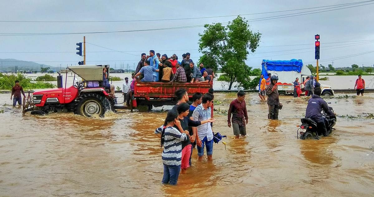 Nalasopara: People wade through a waterlogged road after heavy monsoon rains, in Nalasopara. (PTI Photo)
