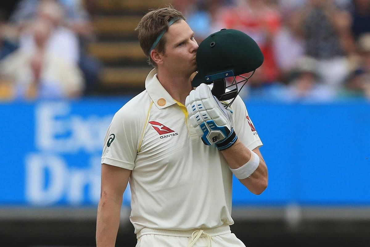 Australia's Steve Smith kisses his helmet as he celebrates reaching his century during play on the fourth day of the first Ashes cricket Test match (AFP Photo)