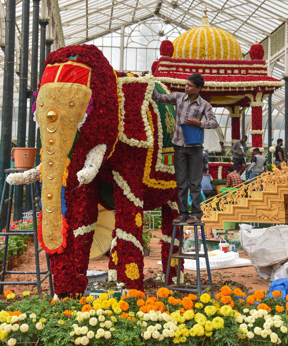 Horticulture Department workers decorating glass house on the eve of 210 Independence Day Flower Show, this year attraction is floral tribute to Maharaja Jayachamaraja Wadiyar. (DH Photo | S K Dinesh)