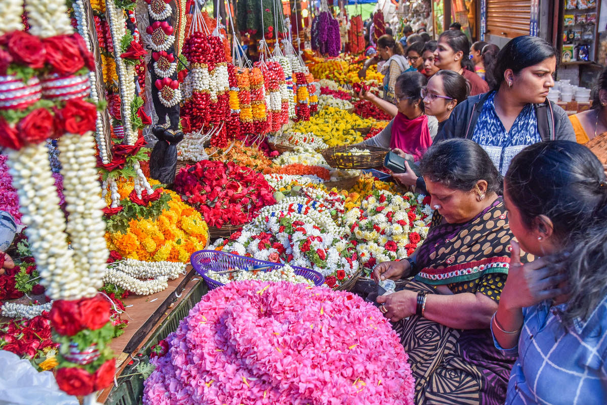 Women purchasing flowers on the eve of Varamahalakshmi festival at Gandhi Bazaar in Bengaluru on Thursday. (DH Photo | S K Dinesh)