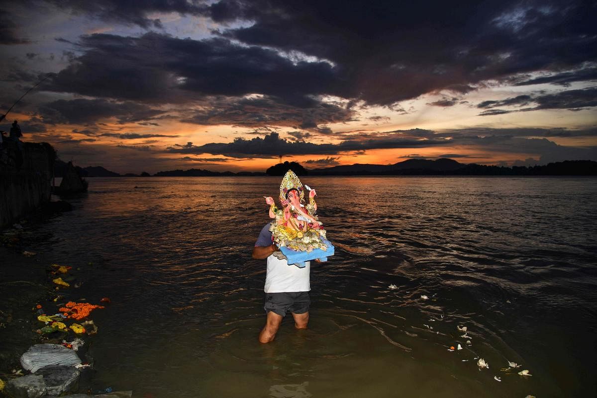 A devotee immerses an idol of the Hindu deity Ganesh in a river during the Ganesh Chaturthi festival in Guwahati on September 3, 2019. (AFP Photo)