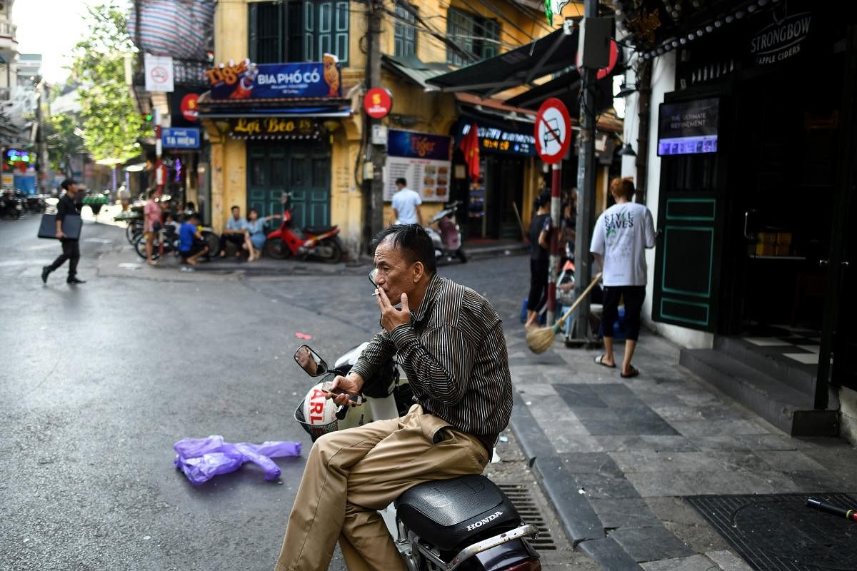 A Vietnamese man smokes a cigarette while waiting on a street in the old quarters of Hanoi on September 3, 2019. (AFP Photo)