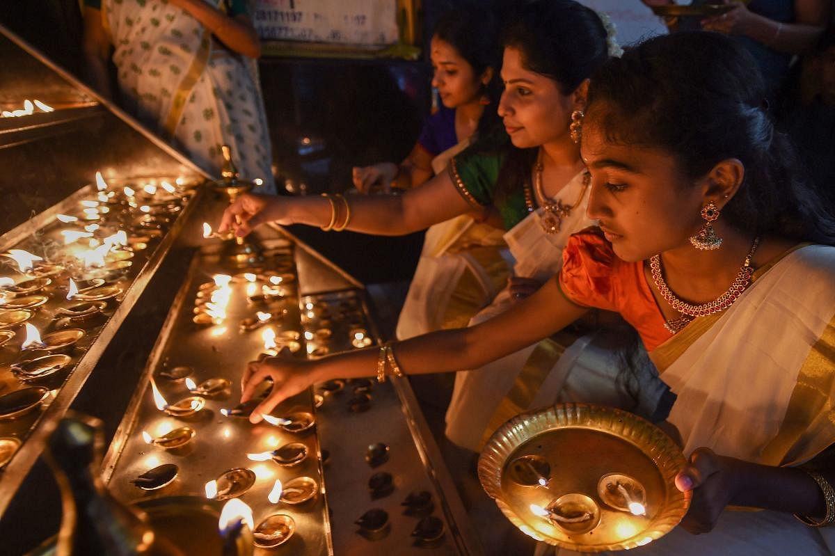 Women light lamps at a temple during Onam celebrations in Chennai. PTI