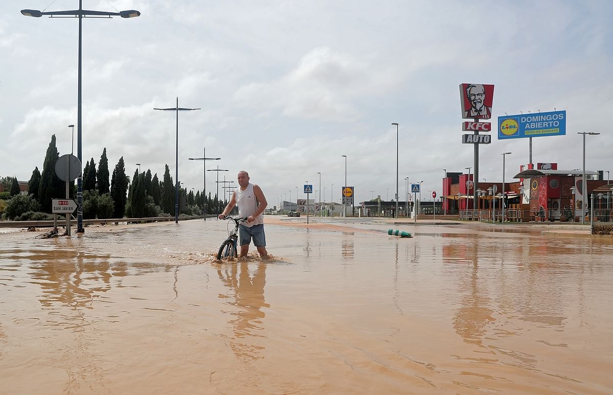 A man wades through a flooded street after heavy rains in San Javier, Spain