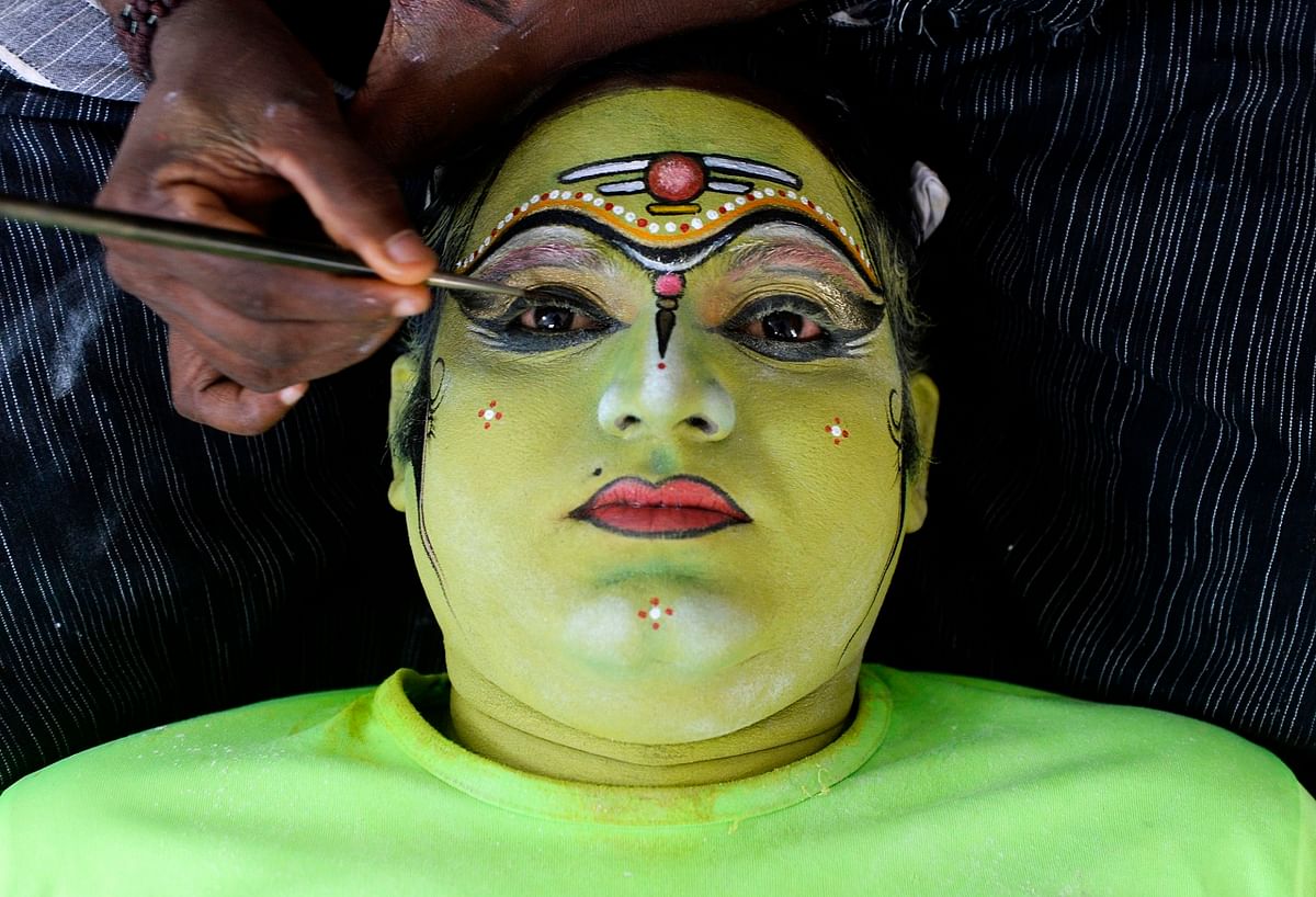 A performer has his face painted before performing as a Hindu god in a 'Kummati Kali', a mask dance, part of the annual Onam festival celebrations in the Thrissur district