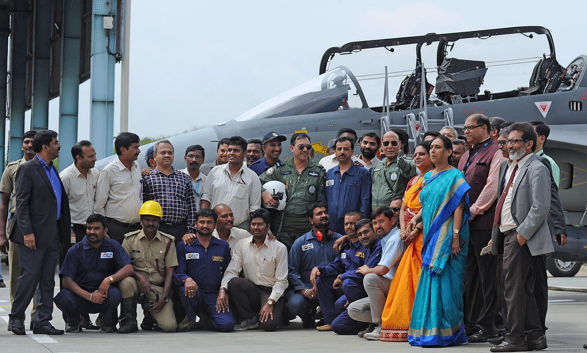 Defence Minister Rajnath Singh stands with the staff of HAL and project staff after flying the Tejas fighter aircraft from the HAL airport in Bengaluru on Thursday