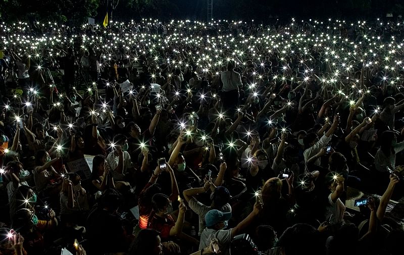 Pro-democracy students wave mobile phones with flashlights switched on, during a large rally at Thammasat University in Pathum Thani, north of Bangkok. (PTI Photo)