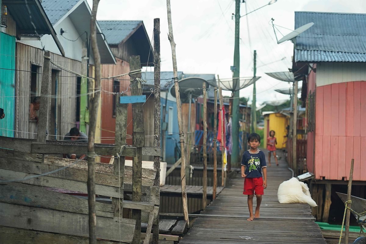 A boy walks through the town of Carauari where residents fear the reach and spread of the coronavirus COVID-19 pandemic, in Brazil. (Credit: AFP)