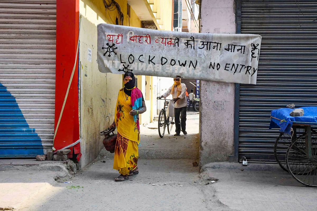 A woman walks past a 'No Entry' banner set up at an alleyway to restrict the movement of people during the nationwide lockdown, in wake of the coronavirus pandemic, in Patna. (PTI Photo)