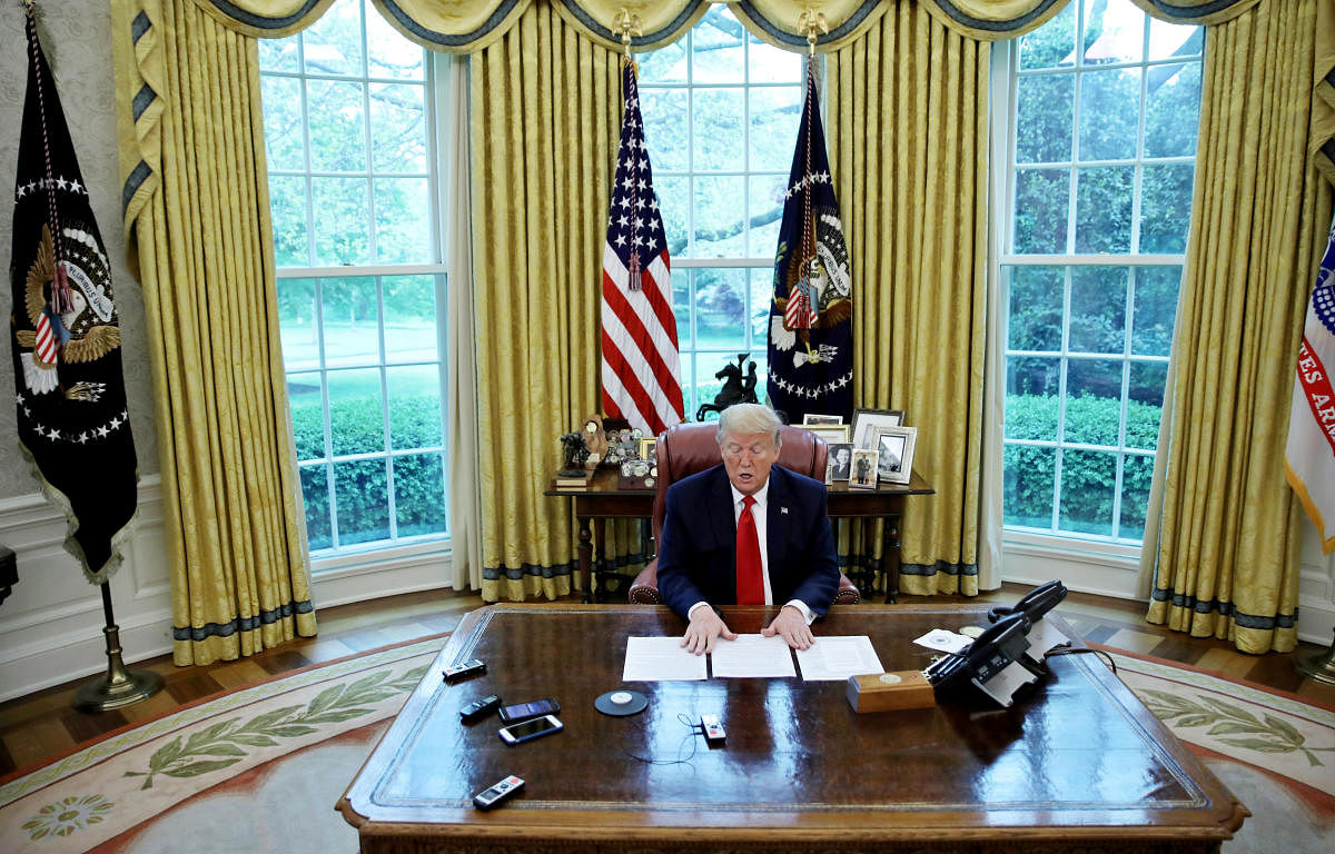 U.S. President Donald Trump looks at his briefing papers as he answers questions during an interview with Reuters about China, the novel coronavirus (COVID-19) pandemic and other subjects in the Oval Office of the White House in Washington, U.S. (Reuters photo)
