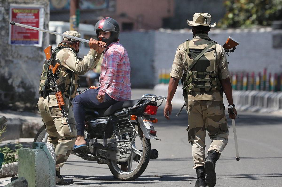 Security personnel baton charge on a commuter at Gurha Bakshi Nagar area, during the ongoing COVID-19 lockdown, in Jammu, Thursday, May 07, 2020. (PTI Photo)