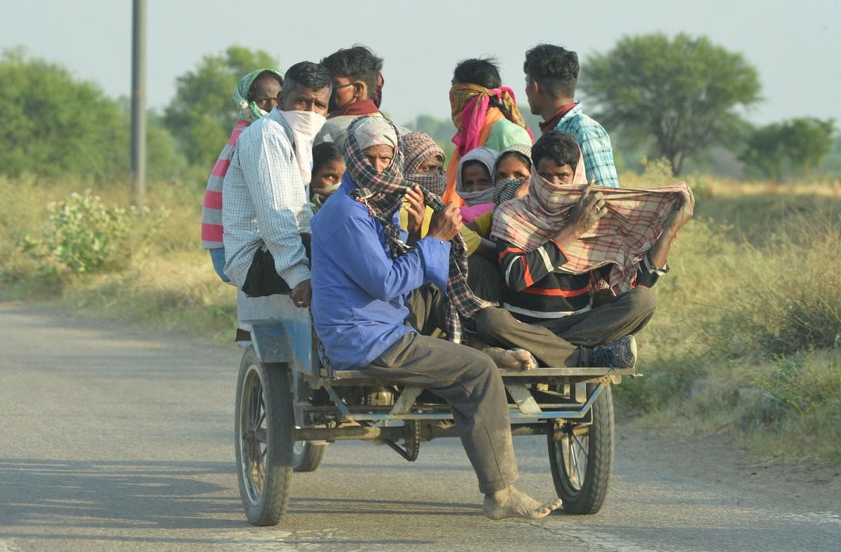 Migrant workers from Uttar Pradesh ride a modified vehicle to reach bus stations on their way to their native places, amid nationwide COVID-19 lockdown, near Chandigarh, Thursday, May 7, 2020. (PTI Photo)