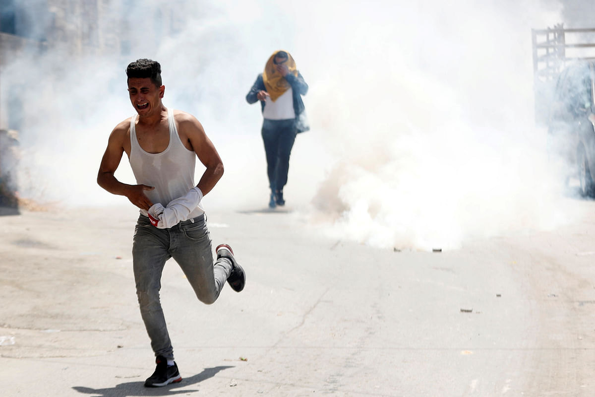 Palestinians run away from tear gas fired by Israeli forces during a raid after an Israeli soldier was killed by a rock, in Yabad near Jenin in the Israeli-occupied West Bank. (Reuters photo)