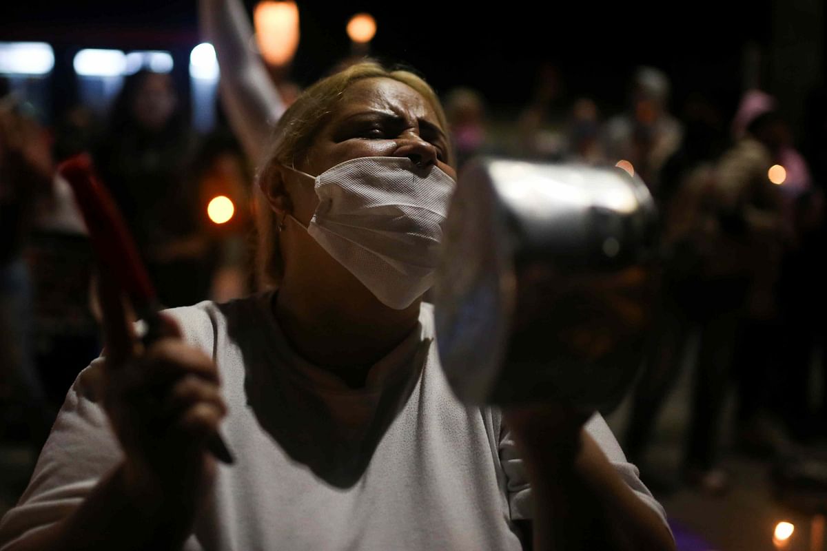 A woman wearing a face mask bangs a pot as relatives of prisoners protest in front of La Picota prison against overcrowding in the country's prisons, in Bogota, Colombia. (Reuters photo)
