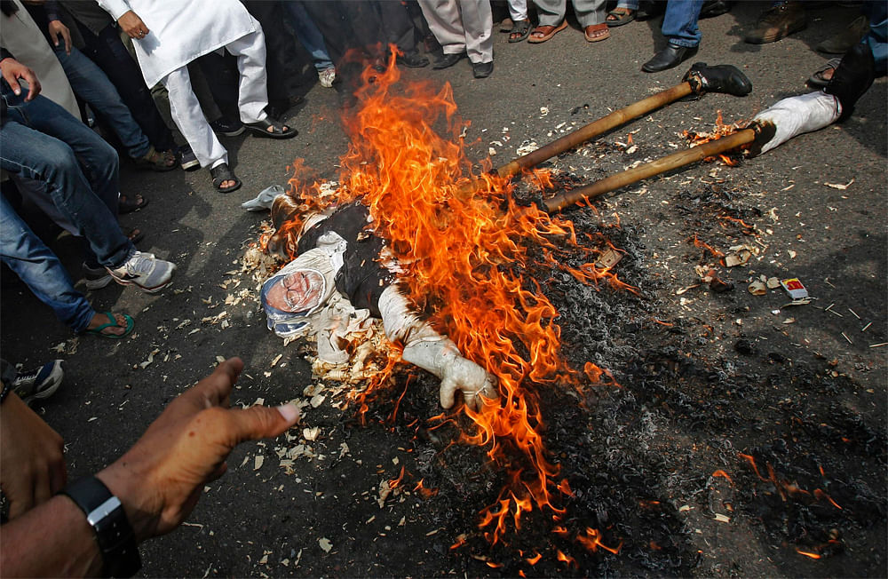 Activists of India's main opposition Hindu nationalist Bharatiya Janata  Party (BJP) burn an effigy of Indian Prime Minister Manmohan Singh  during a nationwide strike in the old quarters of Delhi September 20,  2012. Schools, shops and government of...