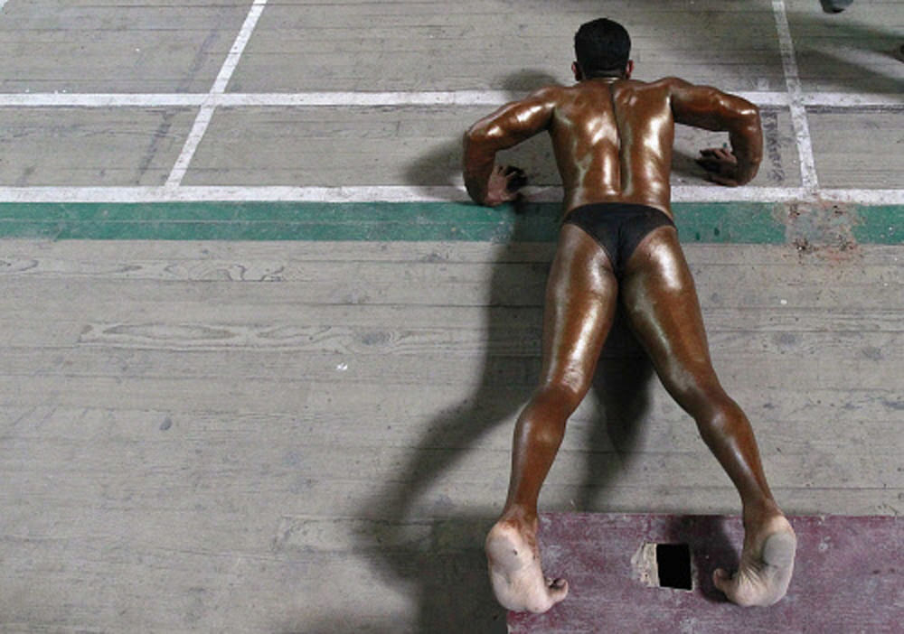 A participant does push-ups backstage during a bodybuilding competition  in Srinagar September 20, 2012. A total of 70 participants are competing  in different bodybuilding categories, organisers said.  REUTERS