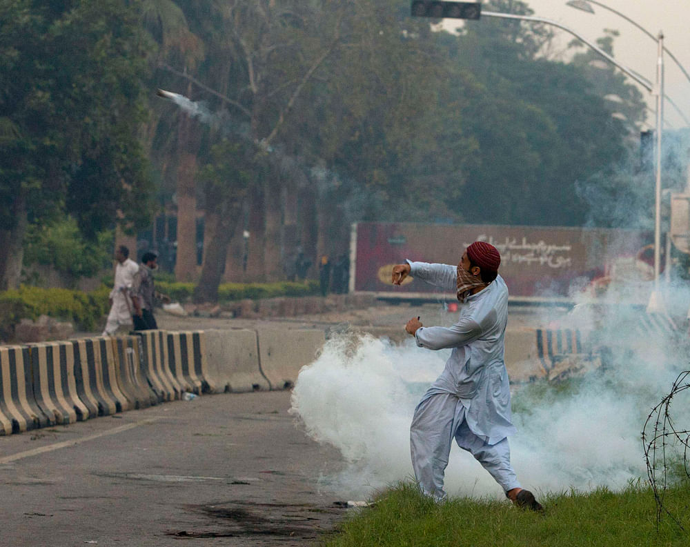 A supporter throws a teargas canister, which was earlier thrown by police, during clashes along a road which leads to the U.S. embassy in Islamabad September 20, 2012. Some 800 protesters march towards the U.S. embassy gathered in a demonstration to ...