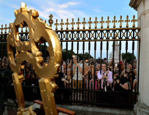 Crowds of people try to look at a notice formally announcing the birth  of a son to Britain's Prince William and Catherine, Duchess of  Cambridge, placed in the forecourt of Buckingham Palace, in central  London July 22, 2013. Prince William's wife K...