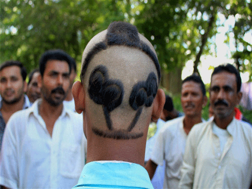A Trinamool Congress supporter displays his  hairdo in the shape of  party symbol ahead of 5th and final phase of panchayat election, at  Balurghat in South Dinajpur district on Tuesday. PTI Photo